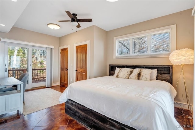 bedroom with access to exterior, ceiling fan, and dark tile patterned floors