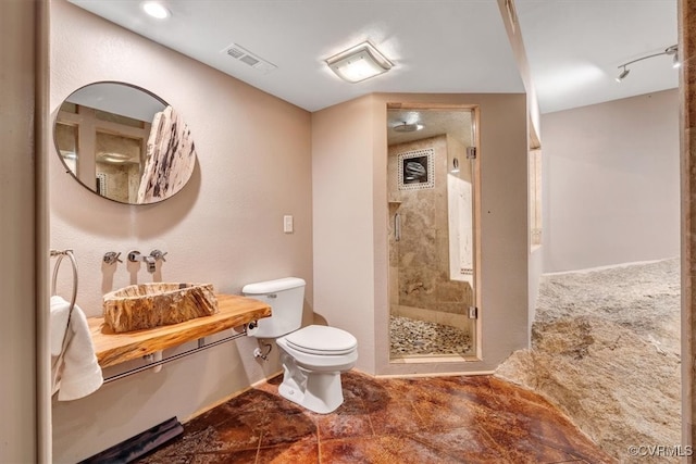 bathroom with toilet, walk in shower, and sink