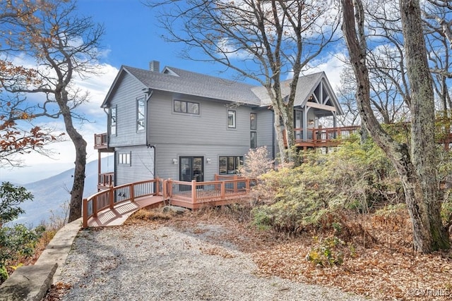 back of property featuring a deck with mountain view