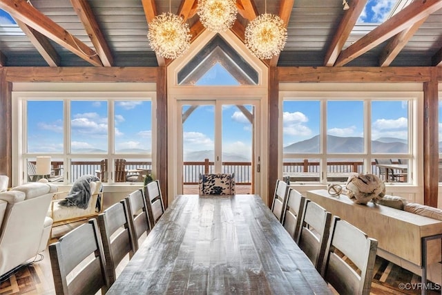 dining space with vaulted ceiling with beams, a mountain view, plenty of natural light, and an inviting chandelier