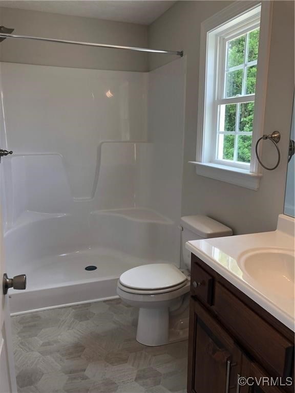 bathroom featuring a shower, vanity, and toilet