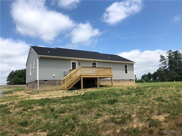 back of property featuring a wooden deck and a yard