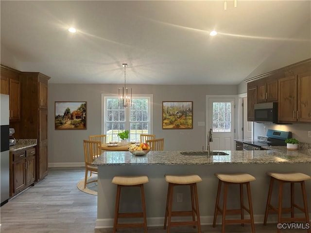 kitchen with light wood-type flooring, a wealth of natural light, sink, and stainless steel appliances