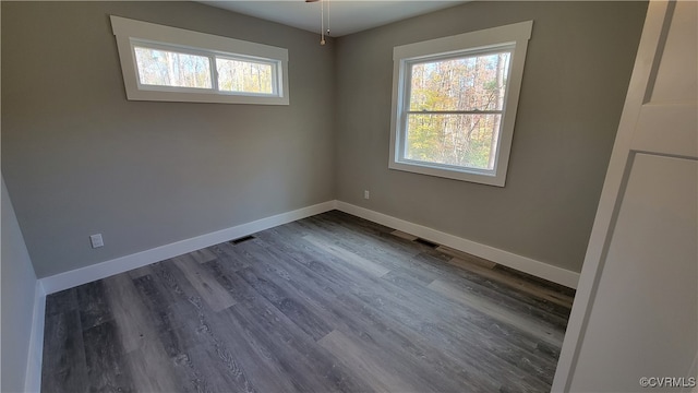 unfurnished room featuring plenty of natural light, ceiling fan, and dark hardwood / wood-style flooring