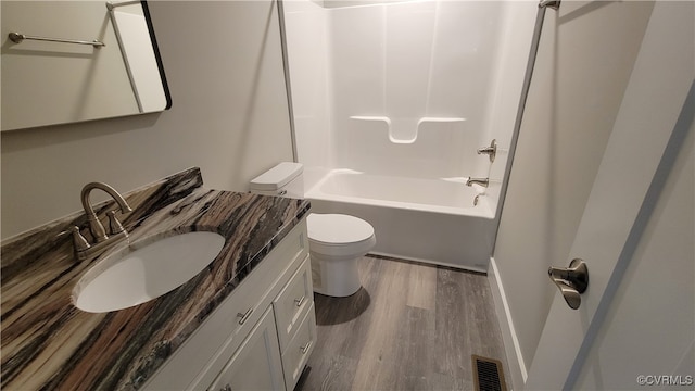 full bathroom featuring vanity, hardwood / wood-style flooring, tub / shower combination, and toilet