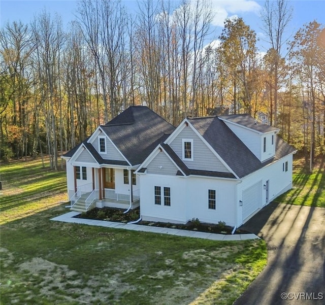 view of front of property with a front lawn, a garage, and covered porch