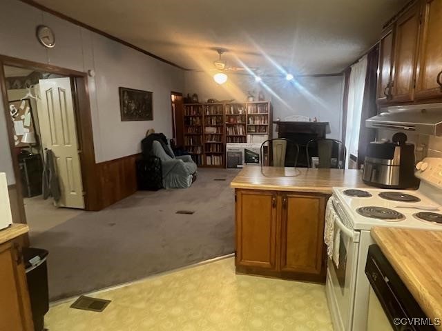 kitchen with electric stove, light carpet, wooden walls, dishwashing machine, and ceiling fan