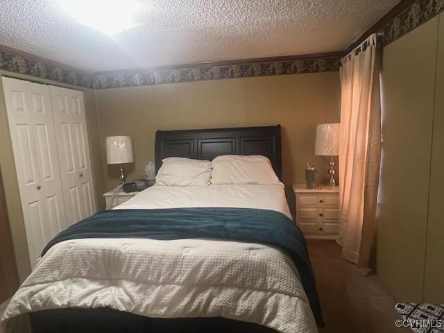 carpeted bedroom with a closet and a textured ceiling