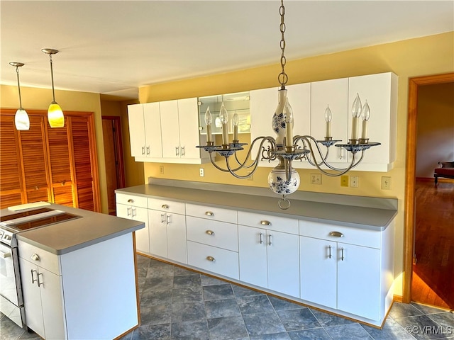 kitchen with white cabinetry, white range, and decorative light fixtures