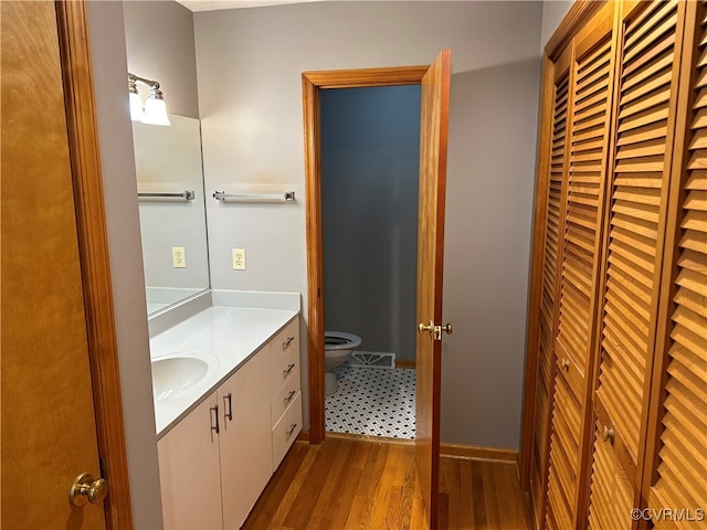 bathroom featuring toilet, vanity, and hardwood / wood-style flooring