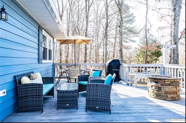 wooden deck featuring grilling area and an outdoor fire pit