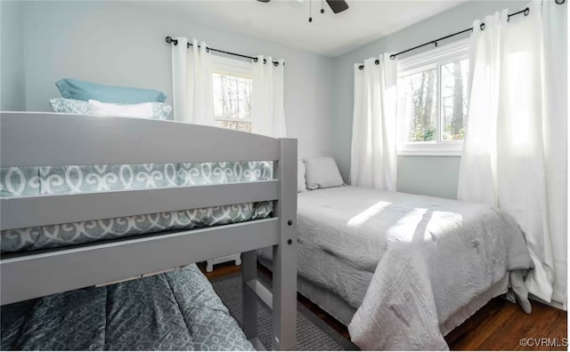 bedroom featuring dark hardwood / wood-style flooring, multiple windows, and ceiling fan