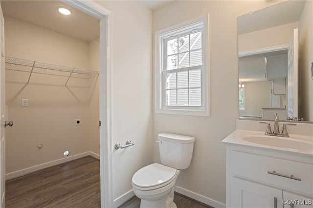 bathroom with hardwood / wood-style floors, vanity, and toilet