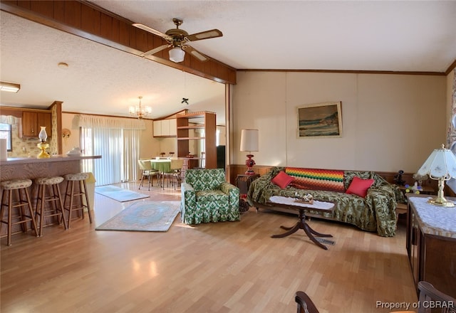 living room featuring a textured ceiling, light hardwood / wood-style floors, and vaulted ceiling