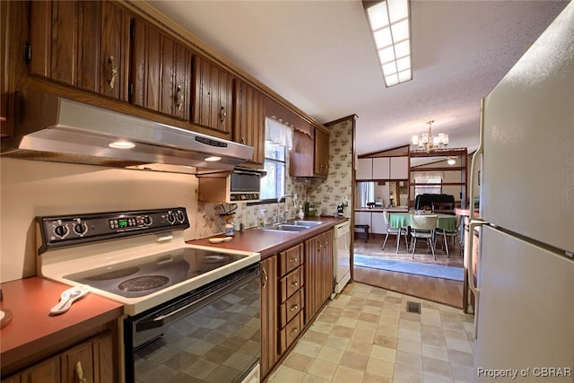 kitchen with sink, an inviting chandelier, white appliances, and light wood-type flooring