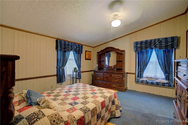 bedroom featuring a textured ceiling, carpet floors, ceiling fan, and ornamental molding