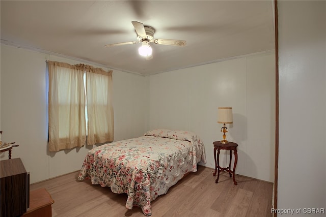 bedroom featuring ceiling fan, light hardwood / wood-style floors, and crown molding