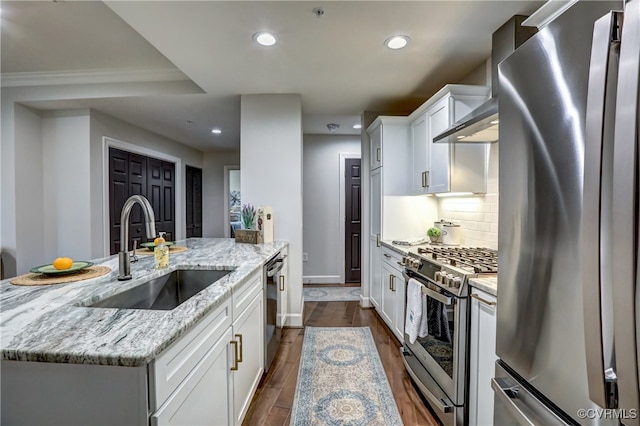 kitchen featuring stainless steel appliances, white cabinets, sink, a kitchen island with sink, and light stone countertops