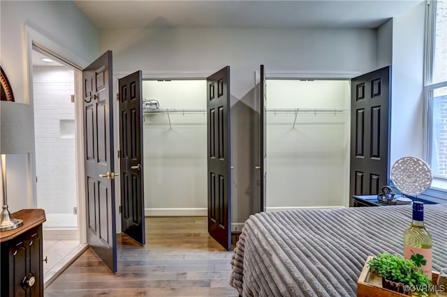 bedroom featuring hardwood / wood-style flooring and multiple closets