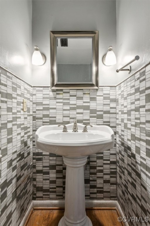 bathroom featuring hardwood / wood-style floors and tile walls