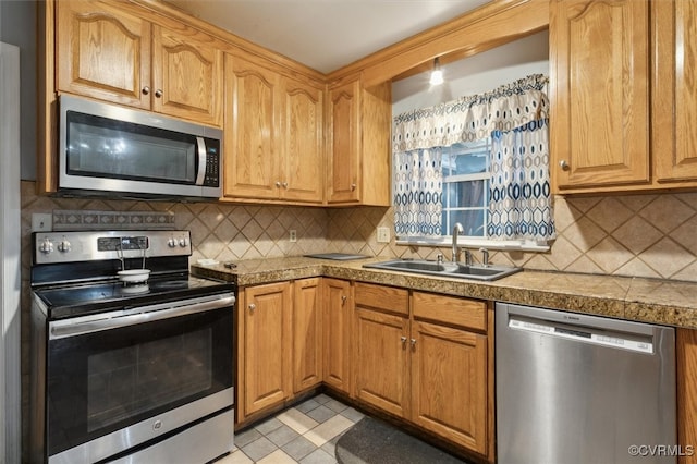 kitchen featuring appliances with stainless steel finishes, tasteful backsplash, and sink