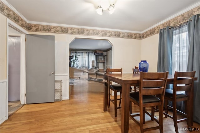 dining area with light hardwood / wood-style flooring and ornamental molding