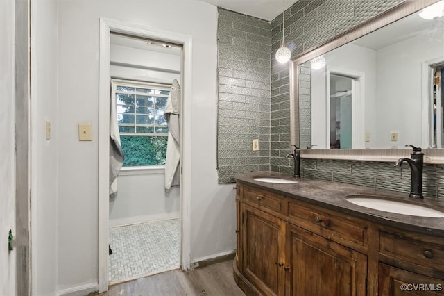 bathroom with tasteful backsplash, vanity, and wood-type flooring