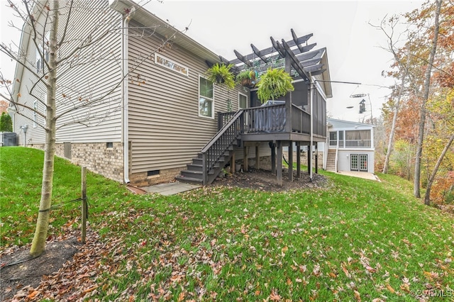 back of house with central AC unit, a sunroom, a yard, and a pergola