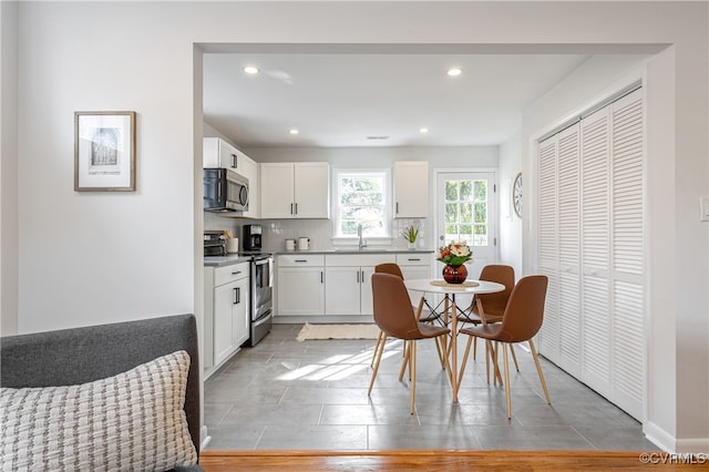 kitchen with white cabinetry, sink, light wood-type flooring, and appliances with stainless steel finishes