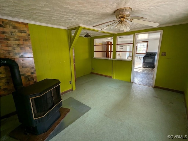 unfurnished living room featuring ceiling fan, ornamental molding, a wood stove, and a textured ceiling