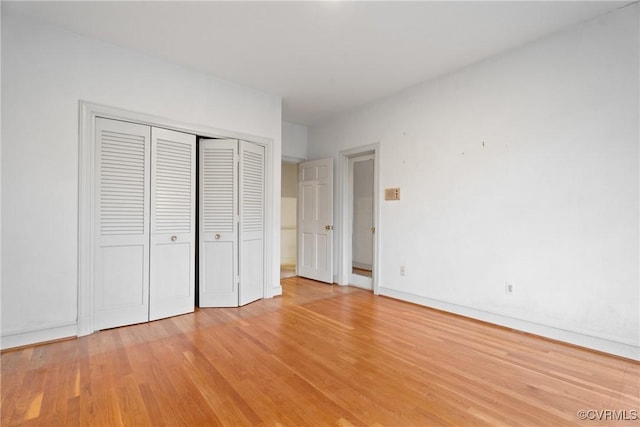 unfurnished bedroom with light hardwood / wood-style floors and a closet