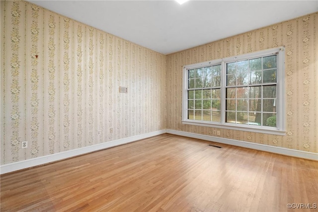 unfurnished room with hardwood / wood-style flooring and a wealth of natural light