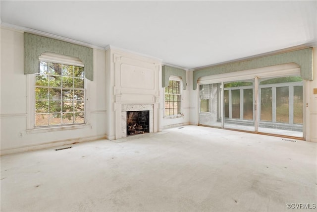 unfurnished living room with carpet, a premium fireplace, and crown molding