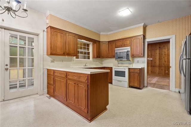 kitchen featuring stainless steel appliances, crown molding, a notable chandelier, and sink