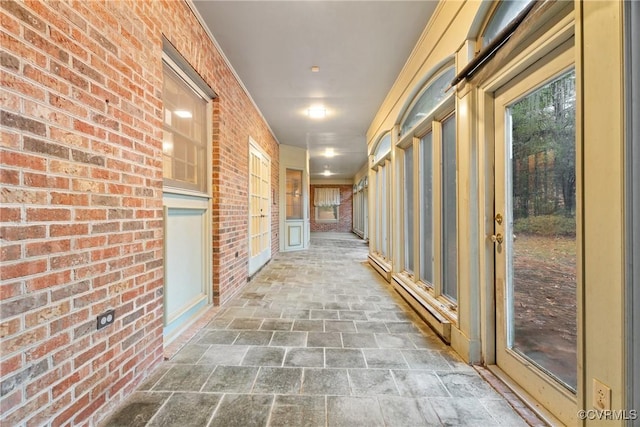 corridor featuring brick wall and a baseboard heating unit