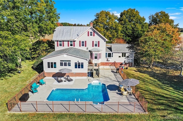 back of house with a patio, a fenced in pool, and a lawn