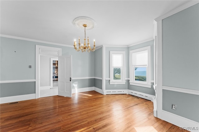 empty room with crown molding, a notable chandelier, and hardwood / wood-style flooring