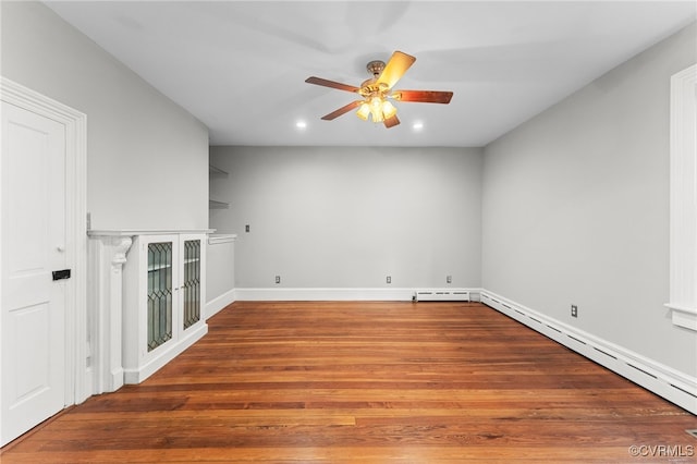 interior space with baseboard heating, ceiling fan, and hardwood / wood-style flooring