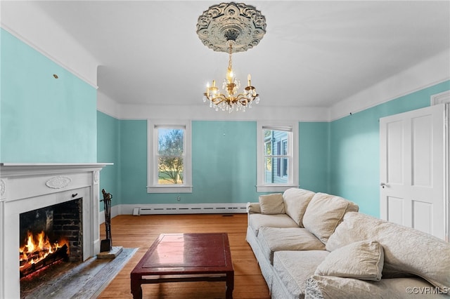 living room featuring hardwood / wood-style floors, a baseboard radiator, and an inviting chandelier