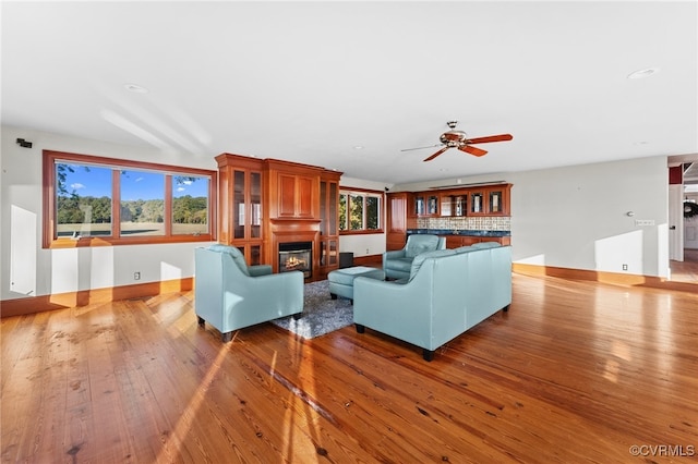 living room featuring a wealth of natural light, ceiling fan, and hardwood / wood-style flooring