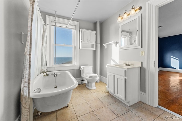 bathroom featuring tile patterned flooring, vanity, toilet, and a bathtub