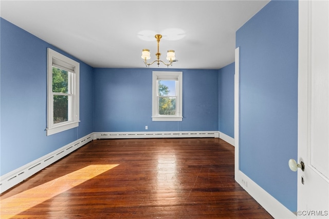 spare room with dark hardwood / wood-style flooring, an inviting chandelier, and a baseboard heating unit