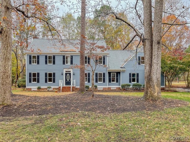 colonial-style house featuring a front yard