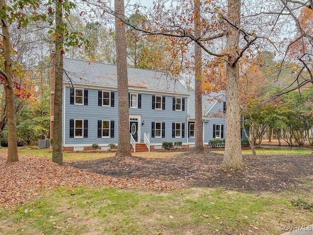 colonial inspired home featuring a front yard and central air condition unit