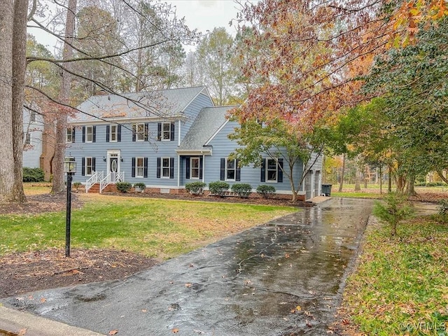 colonial house featuring a garage and a front yard