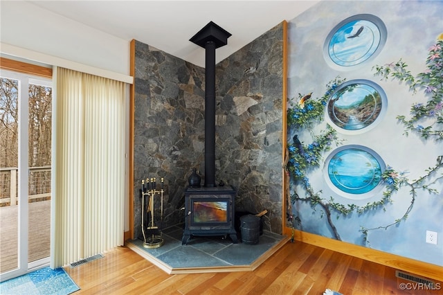 interior space featuring a wood stove and hardwood / wood-style flooring