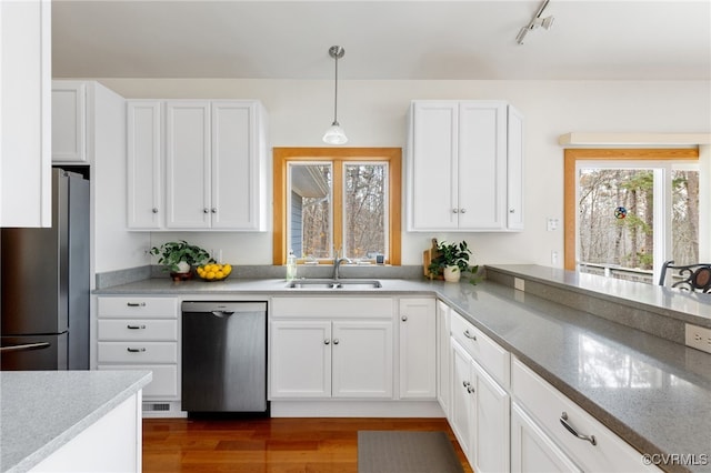 kitchen featuring white cabinetry, pendant lighting, wood-type flooring, and appliances with stainless steel finishes