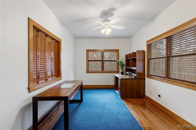 home office with hardwood / wood-style flooring and ceiling fan