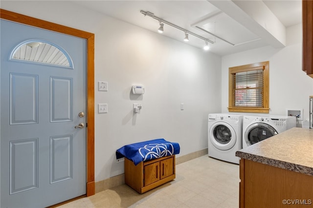 clothes washing area featuring washer and clothes dryer and rail lighting