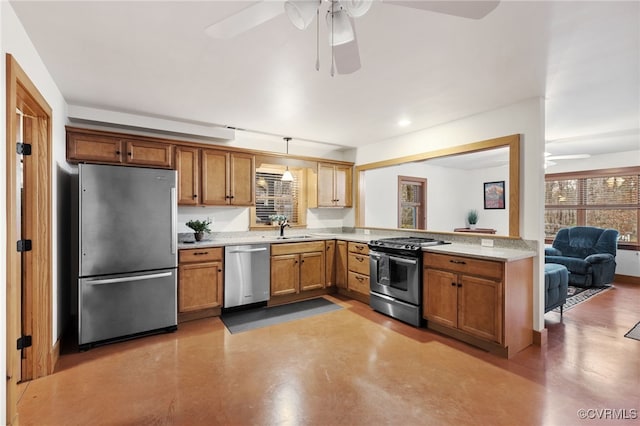 kitchen featuring ceiling fan, sink, stainless steel appliances, and decorative light fixtures